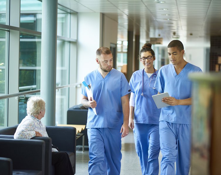 People in scrubs walking together in a healthcare setting