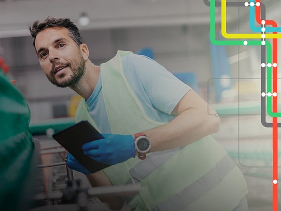 Man holding a tablet observes products in a warehouse