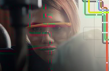 Young adult woman wearing safety glasses operates machinery 