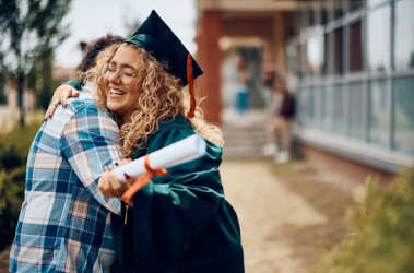 Graduate hugging a friend