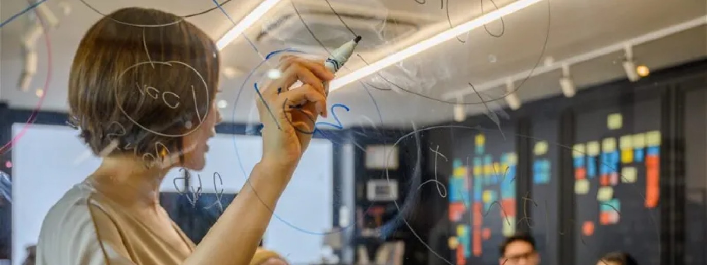 Woman writing on a clear board