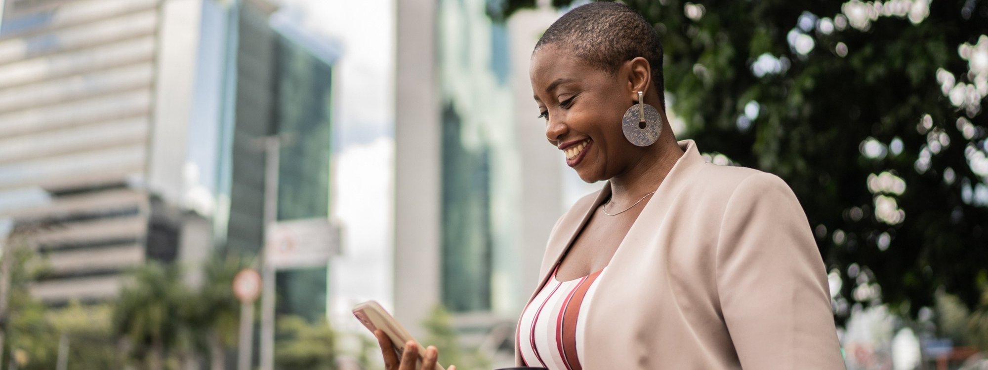 Woman Smiling at Phone Outside