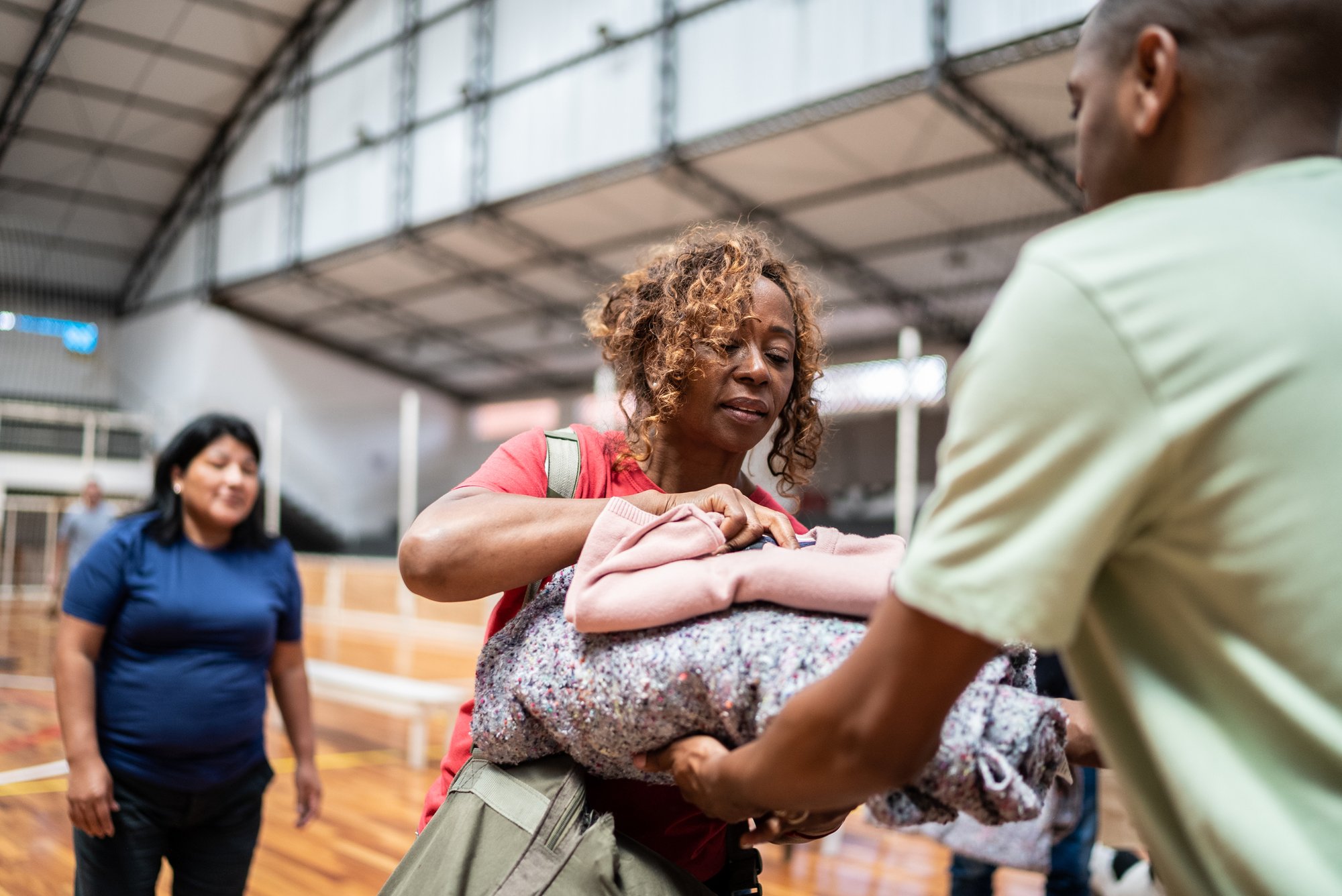 Senior woman receiving a blanket from a soldier at a community center