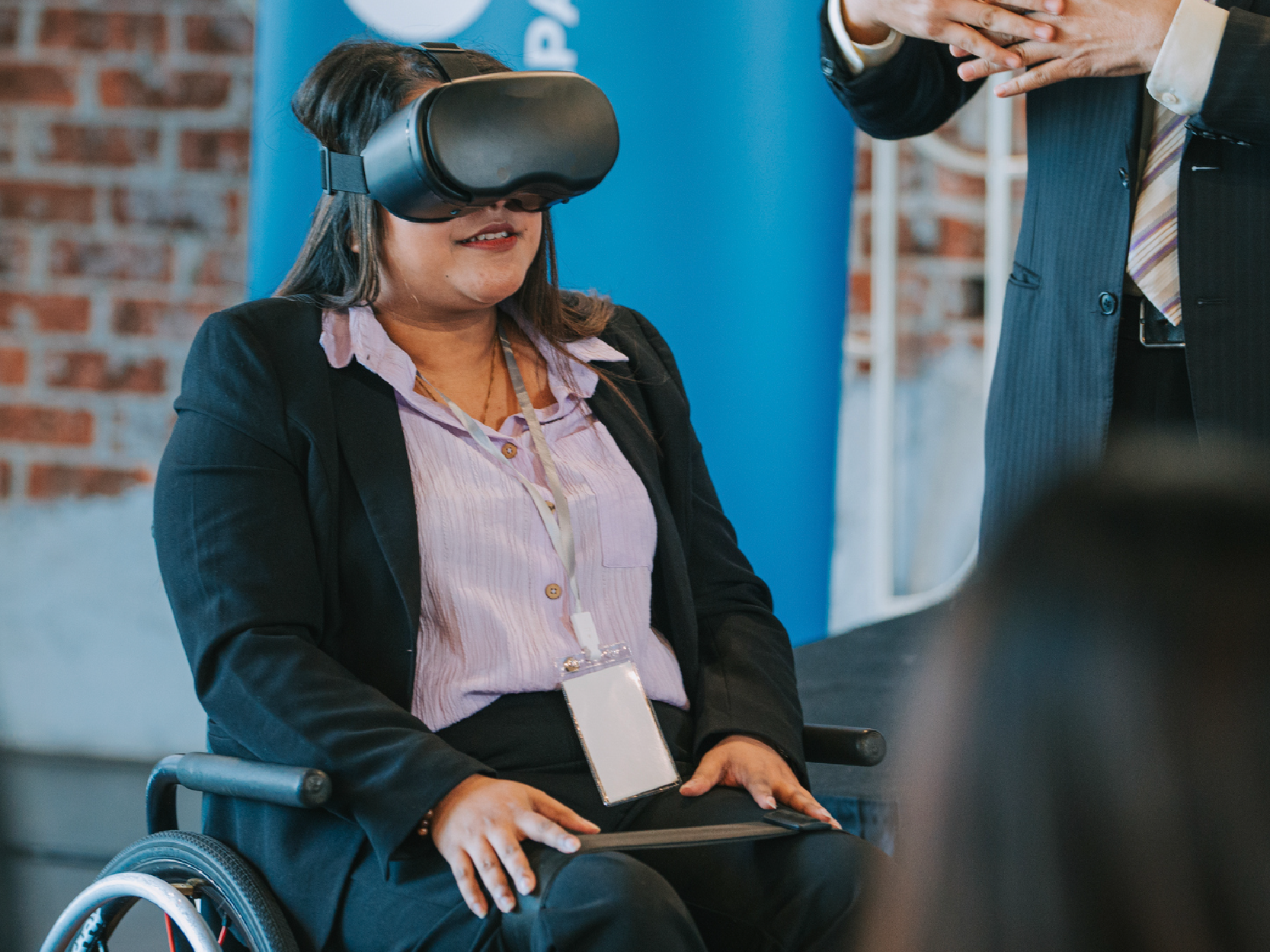 Asian Indian woman in wheelchair trying VR goggle during business conference seminar in convention center